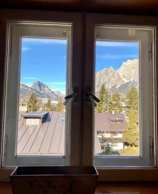 two windows in a room with a view of a mountain at Mansardina Mery Cortina - Studio - in Cortina dʼAmpezzo