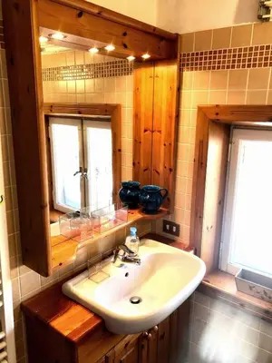a bedroom with a bed with a white sheet on it at Mansardina Mery Cortina - Studio - in Cortina dʼAmpezzo