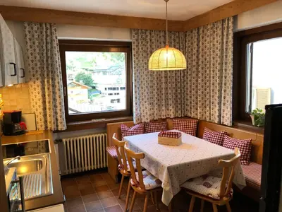 a dining room with a table and chairs and a window at Appartements Tlusel in Ortisei