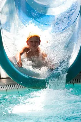 a young child riding a water slide in a pool at Appartements Tlusel in Ortisei