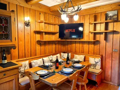 a dining room with a table and a tv at Large Central Flat, 5min to Sky Slopes, Garage in Cortina dʼAmpezzo