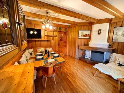 a living room with a table and a couch at Large Central Flat, 5min to Sky Slopes, Garage in Cortina dʼAmpezzo
