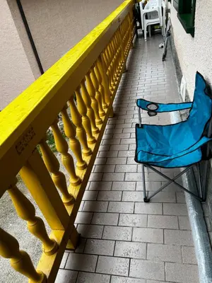 a blue chair sitting next to a yellow railing at SISSI MENDEL Residence in Ronzone