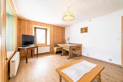 a living room with a table and a television at Appartamento Vecchia Osteria in Rocca Pietore