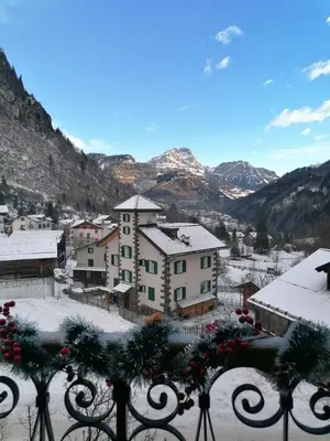 a view of a town with snow covered mountains at Appartamento Vecchia Osteria in Rocca Pietore