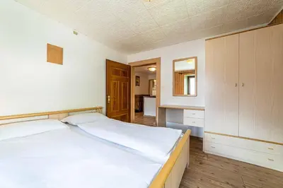 a bedroom with a large white bed and a bathroom at Appartamento Vecchia Osteria in Rocca Pietore