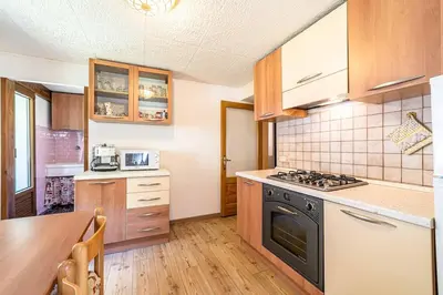 a kitchen with wooden cabinets and a stove top oven at Appartamento Vecchia Osteria in Rocca Pietore