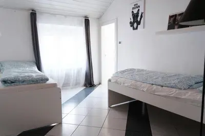 a bedroom with two beds and a window at Druso Rooms in Bolzano