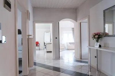 a white room with a hallway with a mirror at Druso Rooms in Bolzano
