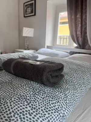 a bed with a towel sitting on top of it at Druso Rooms in Bolzano