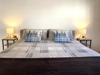 a bed with blue and white pillows and two lamps at Casa LaLu in Cavalese