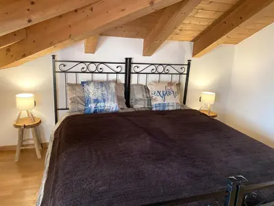 a bedroom with a black bed with two lamps at Casa LaLu in Cavalese