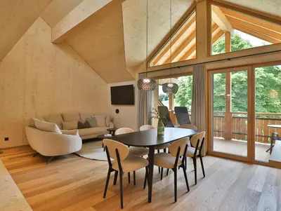 a dining room and living room with a table and chairs at Mair am Graben Farm Chalets in Terento