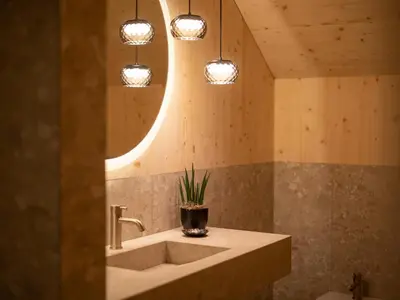 a bathroom with a sink and a mirror and lights at Mair am Graben Farm Chalets in Terento