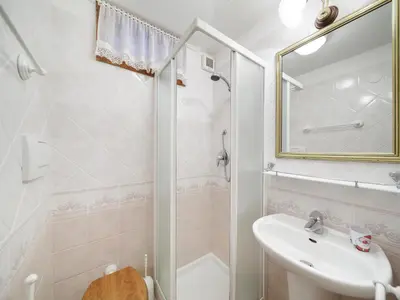 a white bathroom with a shower and a sink at Villa Casanova - Stayincortina in Cortina dʼAmpezzo