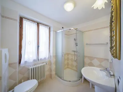 a bathroom with a shower and a toilet and a sink at Villa Casanova - Stayincortina in Cortina dʼAmpezzo