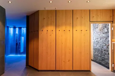 a room with wooden cabinets and a stone wall at Hotel Garni Herz in Tirolo