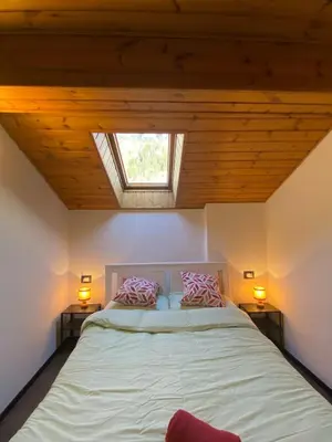 a bedroom with a bed with two pillows on it at Romantica Mansarda Alpina-Ski & Natura in Tesero