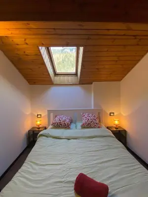 a bedroom with a large bed with a skylight at Romantica Mansarda Alpina-Ski & Natura in Tesero