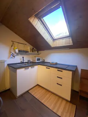 a kitchen with a sink and a skylight at Romantica Mansarda Alpina-Ski & Natura in Tesero