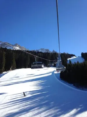 a ski lift going down a snow covered slope at Romantica Mansarda Alpina-Ski & Natura in Tesero