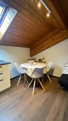 a dining room with a table and chairs at Romantica Mansarda Alpina-Ski & Natura in Tesero