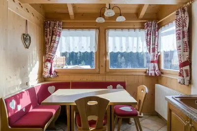 a bedroom with a bed with red sheets and a window at Dolomites with Love in Mazzin