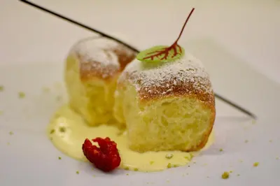 a dessert with a strawberry on a white plate at Pension Garden Hotel in Colfosco