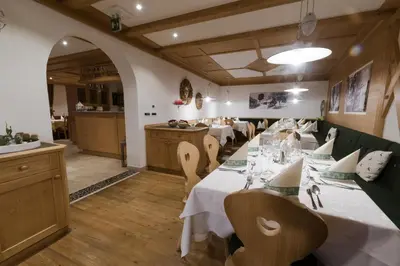 a dining room with a long table and chairs at Pension Garden Hotel in Colfosco