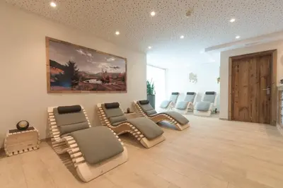 a waiting room with chairs and a painting on the wall at Pension Garden Hotel in Colfosco