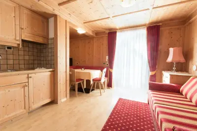 a kitchen and a dining room with a table at Pension Garden Hotel in Colfosco