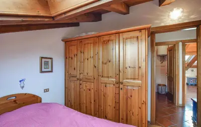 a bedroom with a wooden cabinet and a bed at Lovely Apartment In San Vito Di Cadore in San Vito di Cadore