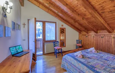 a bedroom with a bed and a laptop on a desk at Lovely Apartment In San Vito Di Cadore in San Vito di Cadore