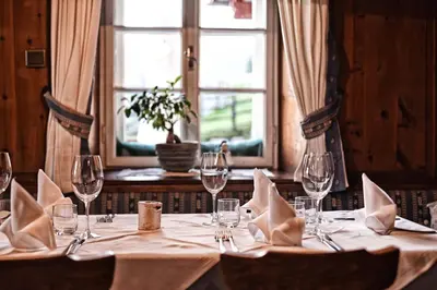 a table with wine glasses and napkins on it at Oberraut in Brunico