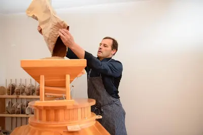 a man in an apron working on a piece of wood at Oberraut in Brunico