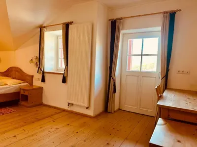 a bedroom with a bed and a window and a door at Oberraut in Brunico