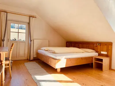 a bedroom with a bed and a table and a window at Oberraut in Brunico