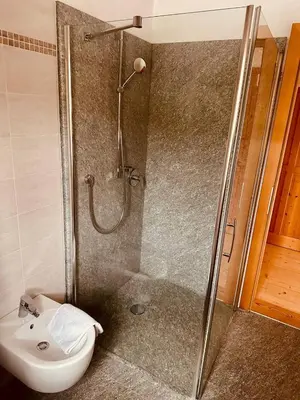 a bathroom with a shower and a toilet and a sink at Oberraut in Brunico