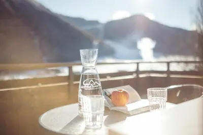 a glass vase sitting on a table with an apple at HoferVals in Valles