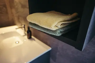 a bathroom with a white sink and towels on a shelf at HoferVals in Valles
