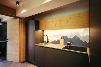 a kitchen with a large painting of mountains on the wall at HoferVals in Valles