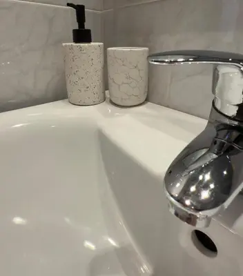 a sink with a faucet and two cups on it at AlpinVista- Le Maddalene in Cavareno