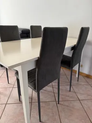 a white table with four black chairs around it at AlpinVista- Le Maddalene in Cavareno