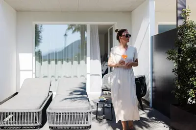a woman in a white dress standing in a room with beds at Hotel Paradies in Tirolo