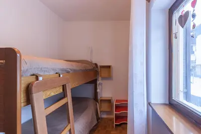 a room with two bunk beds and a window at Condominio Val Biois in Falcade
