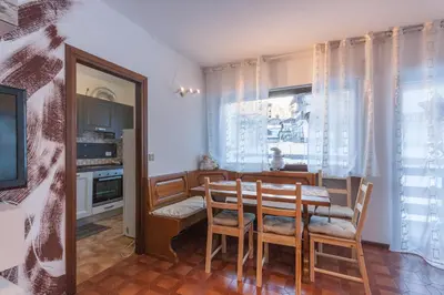 a kitchen and dining room with a table and chairs at Condominio Val Biois in Falcade