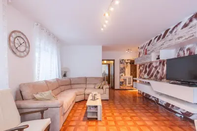 a living room with a couch and a flat screen tv at Condominio Val Biois in Falcade