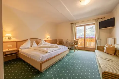 a hotel room with a bed and a window at Hotel Garni Alpes in Schenna