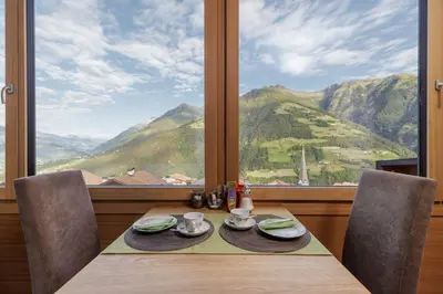 a dining table with a view of a mountain at Hotel Garni Alpes in Schenna