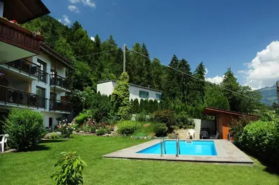 a swimming pool in a yard next to a building at Haus Rosengarten in Tirolo